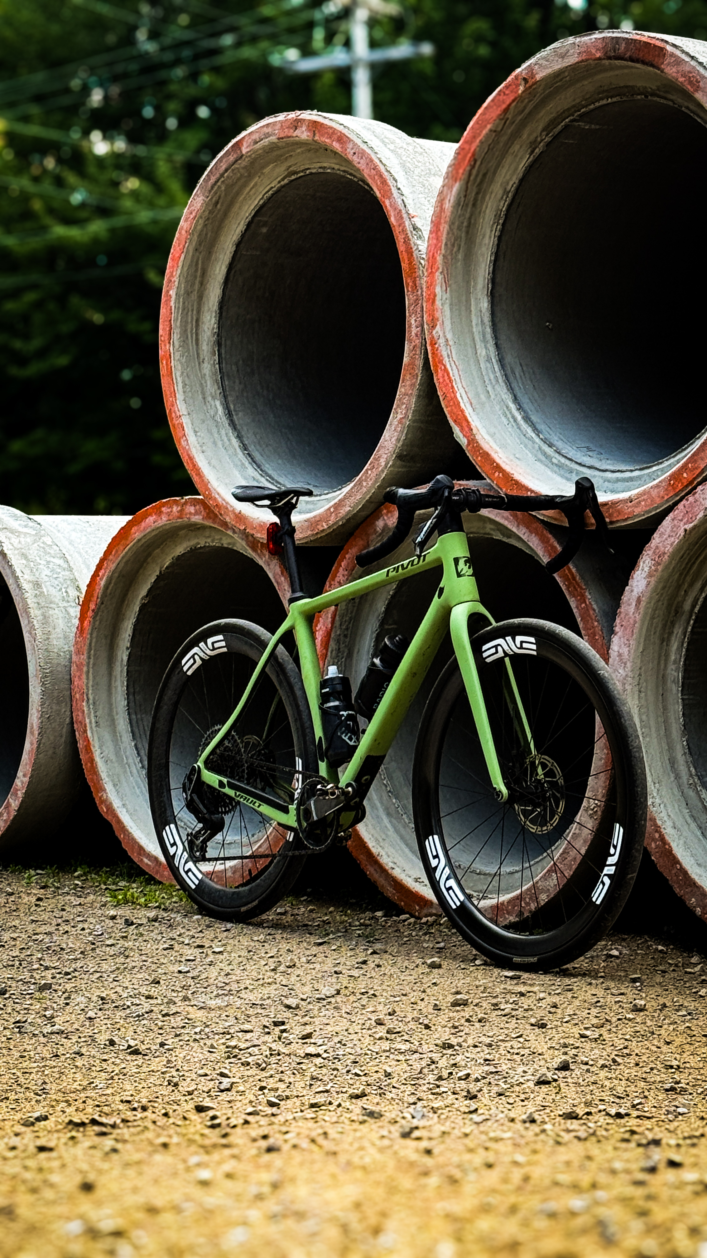 Vélo gravel appuyé contre des tuyaux de béton