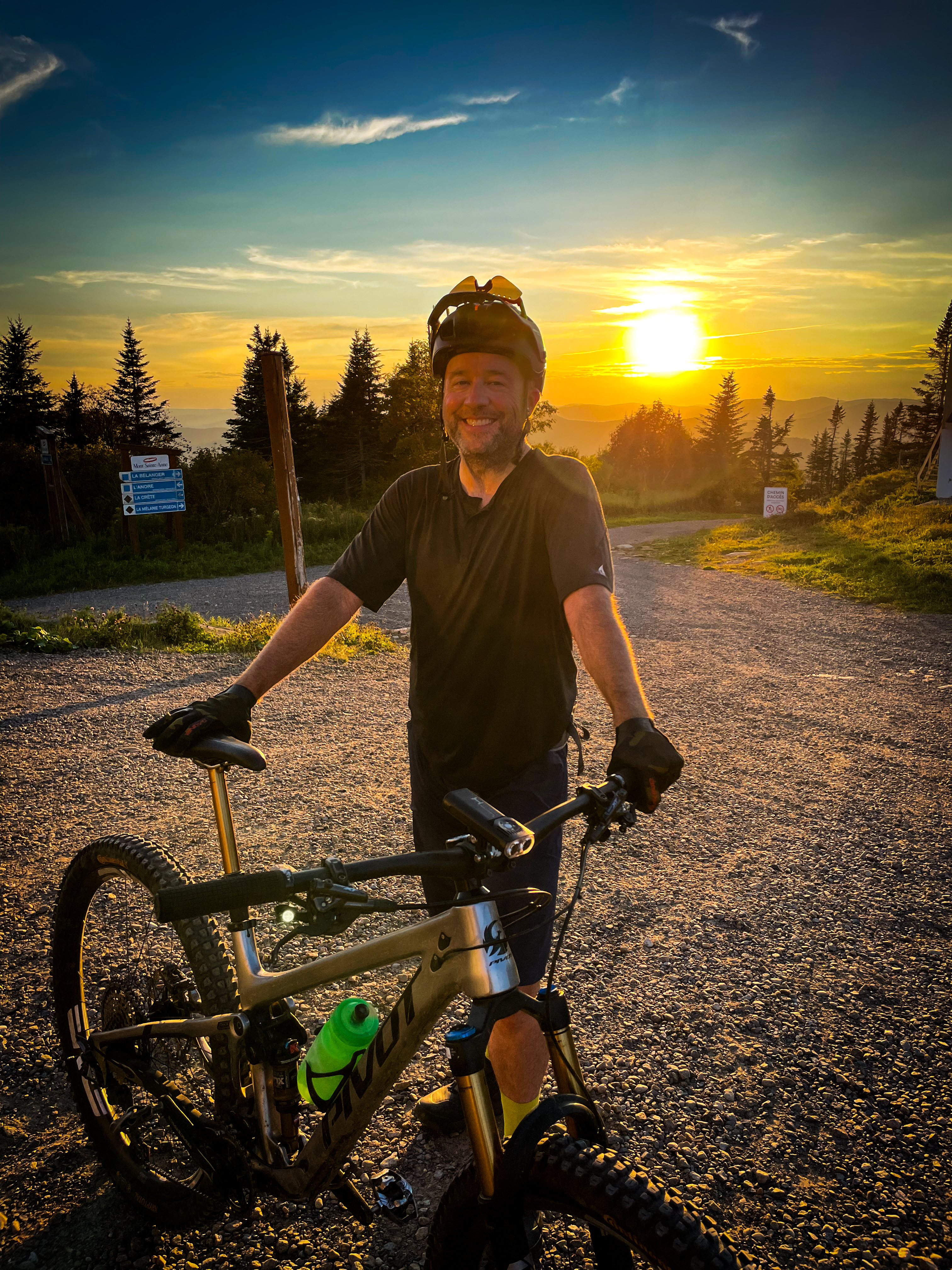 Emmanuel Moisan souriant avec son vélo Pivot au coucher du soleil